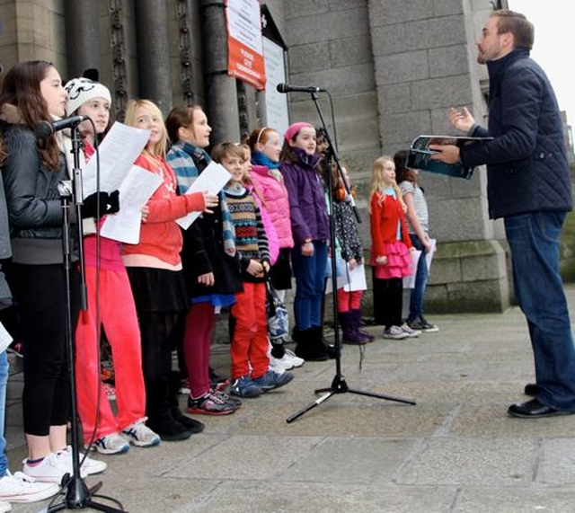 Ian Packham conducts the choir of the Kildare Place School at the launch of the 2013 Black Santa Sit Out at St Ann’s Church, Dawson Street, today (December 18). The sit out charity collection will continue outside the church until Christmas Eve. 