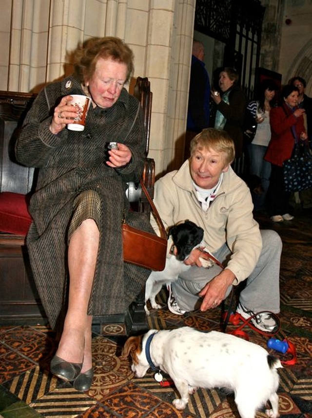 Kathleen O’Callaghan enjoys a cup of tea and a mince pie while Ann Gahan’s dogs Gypsie and Bobby put themselves to good use collecting the crumbs following the Peata Carol Service in Christ Church Cathedral. 