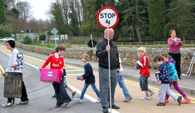 The rector of Powerscourt, Archdeacon Ricky Rountree, was on hand to help the children of Powerscourt NS cross the road on the final leg of their journey to their new school building. 