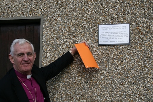 The Most Revd Dr John Neill, Archbishop of Dublin, unveils the plaque at the tree planting as part of the ecumenical service at Mount Seskin Community College, Tallaght.
