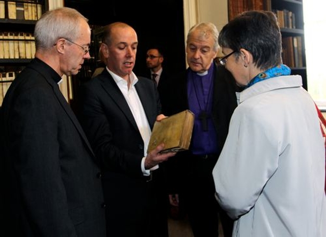 Archbishop Justin Welby, Dr Jason McElligott, Archbishop Michael Jackson and Caroline Welby examining a book which was pierced by a bullet in the 1916 Rising in Archbishop Marsh’s Library during the Dublin leg of the Archbishop of Canterbury’s visit to the Church of Ireland. 