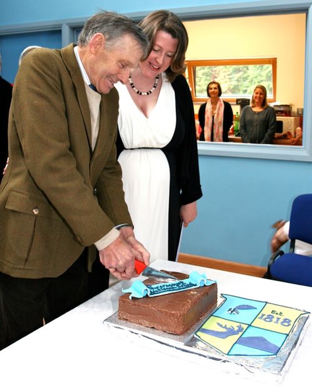 Past pupil of Powerscourt National School, Harry Williams, cuts the cake at the official opening of the new school. 