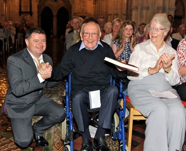 Dr Donald Caird is presented with a copy of his autobiography by the author, Aonghus Dwane. Also pictured is Nancy Caird. 