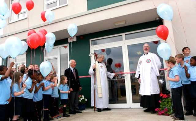 As Archbishop Michael Jackson cuts the ribbon at the official opening of the new building of Athy Model School, the pupils prepare to let go their balloons. 