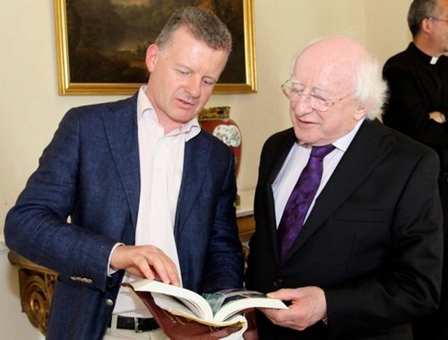 Trevor Sargent shows his book to President Michael D Higgins during the visit of Cumann Gaelach na hEaglaise to Áras an Uachtaráin.