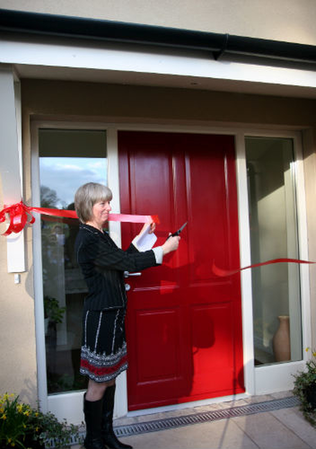 Elizabeth Rountree cuts the ribbon at the dedication of the new rectory at Powerscourt, Enniskerry. 