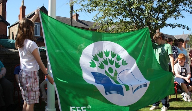 Pupils from Zion Parish School prepare the green flag to be hoisted at the ceremony. 