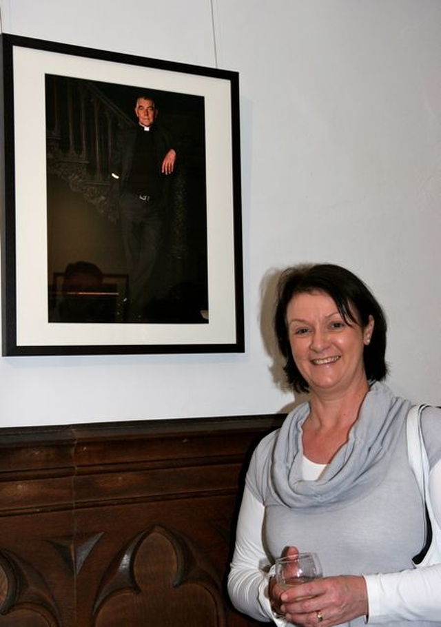 Denise Pierpoint poses beside a photograph of her husband, Archdeacon David Pierpoint, at the opening of the inaugural exhibition, ‘Reflections’, in the new St Michan’s community art gallery. 