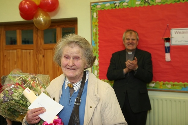 Nora Royds receives a gift in thanks for her service as an organist in the parishes of Newcastle, Newtownmountkennedy and Calary. She was one of five so honoured. In the background, the Rector, the Revd William Bennett applauds.