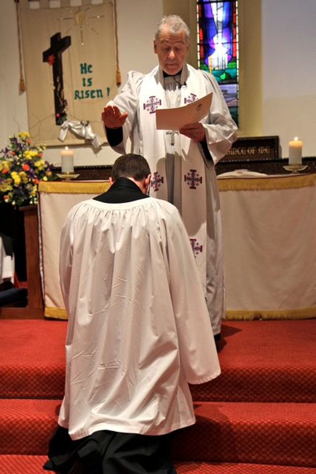 The Revd Arthur Young kneels before Archbishop Michael Jackson during his institution as the new rector of Kill O’ The Grange on April 18.