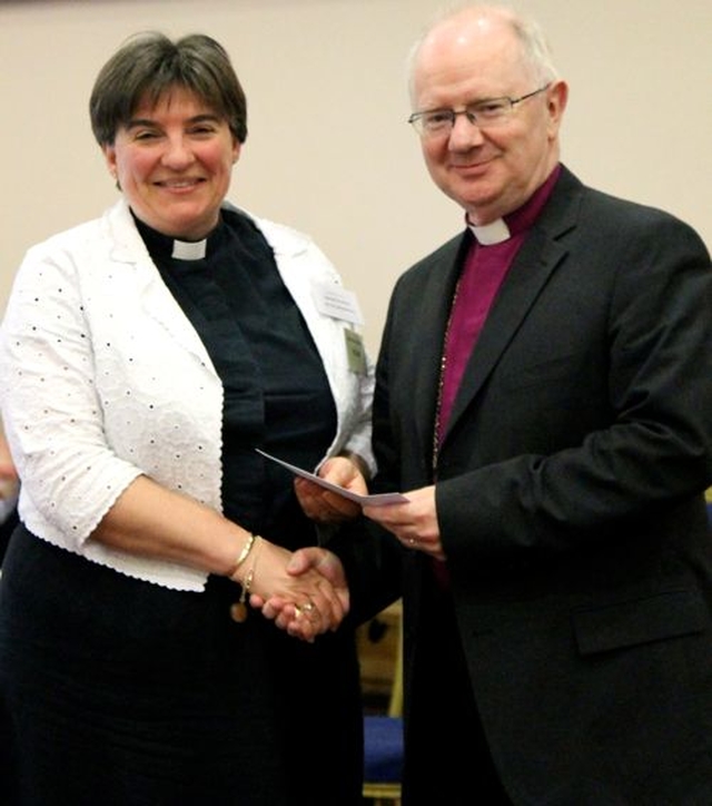 The Revd Gillian Wharton receiving the award for runner up in the parish website category on behalf of Booterstown and Carysfort with Mount Merrion in the Church Of Ireland Communications Competition from the Archbishop of Armagh, the Most Revd Dr Richard Clarke, at General Synod. 