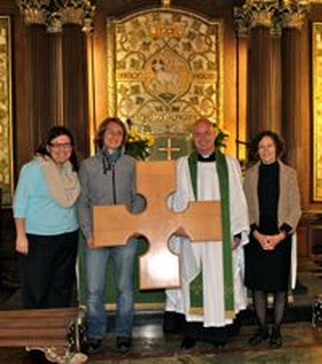 Clodagh O’Reilly and Kirstin Limmer of Solas Project with St Ann’s Vicar, Canon David Gillespie and parishioner, Joan Wadsworth with the cross carved by young people who attend The Yard social enterprise which has been presented to St Ann’s. 