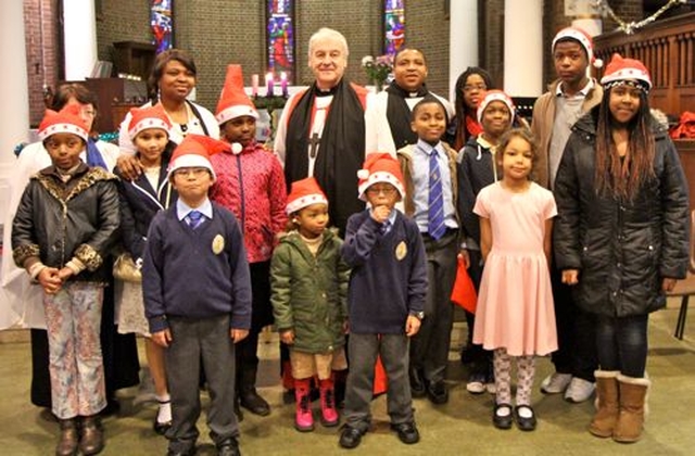 Children who took part in the International Carol Service in St George and St Thomas’s are pictured with Archbishop Michael Jackson, the Revd Obinna Ulogwara and Gillian Dean. 