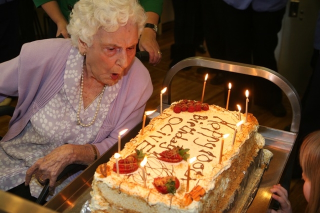 Olive Vaughan blowing out the candles on her birthday cake to celebrate her 100th Birthday in Brabazon house.