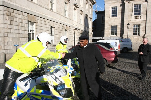 The former Archbishop of Cape Town, the Rt Revd Desmond Tutu greeting his Garda Motorcycle escort at the end of his visit to Trinity College Dublin.