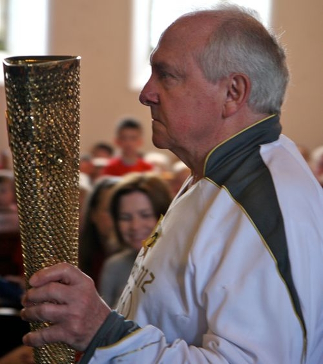 Part time Blessington parishioner, Derek Williams, makes his way up the aisle of St Mary’s Church with the torch he carried with the Olympic Flame in Cardiff. He was a special guest at the West Glendalough Children’s Choral Festival. 