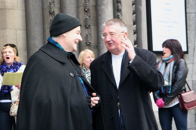 Archbishop Michael Jackson and Archbishop Diarmuid Martin share some festive cheer while the Seafield Singers perform in the background outside St Ann’s Church on Dawson Street.