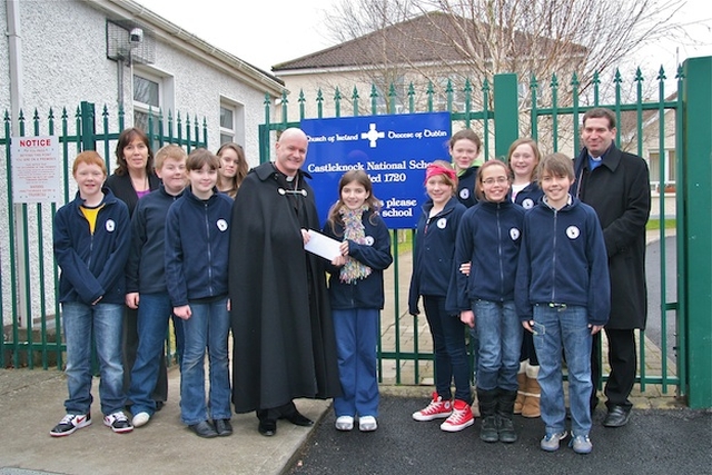 Sixth class students from Castleknock NS presenting the Revd David Gillespie, Vicar at St Ann's, with a cheque for €1,087 for the Black Santa sit-out appeal. Also pictured are Sandra Moloney, principal, and the Revd Victor Fitzpatrick, curate of Castleknock and Mulhuddart with Clonsilla. 