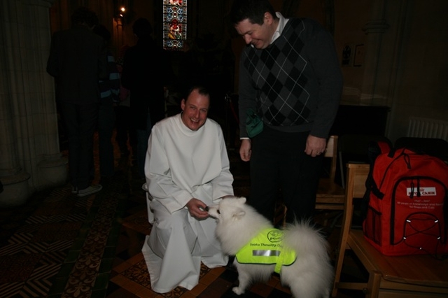 The Revd Roy Byrne, Rector of Drumcondra gets to know a four legged friend at the service in Christ Church Cathedral in aid of Peata.