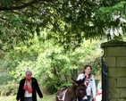 Howard the donkey is escorted into the churchyard of Killiskey Parish Church in Ashford for the Palm Sunday Service. 