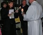 Members of the congregation light their candles as they enter Killiskey Parish Church for the Easter Vigil. 