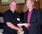 Archbishop Alan Harper presenting the Ven Ricky Rountree, Archdeacon of Glendalough and Chairman of the Church Music Committee, with second prize in the 'other organisation printed publication' category of the General Synod communications awards for ‘Soundboard’ magazine. Photo: David Wynne.