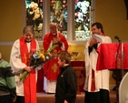 The Revd Terry Alcock, newly ordained to the priesthood receives a bunch of flowers from two young people from the nearby school at her ordination in St James' Church, Castledermot. Looking on are the Archbishop of Dublin and Bishop of Glendalough, the Most Revd Dr John Neill and the Revd Isaac Delamere, Rector of Narraghmore and Timolin with Castledermot and Kinneagh.