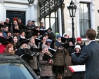 Ruaidhrí Ó Dálaigh conducts Cantairí Avondale at the community carol singing outside the Mansion House in Dublin.