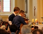Students bring items representing school life to the altar during the service of dedication of Temple Carrig School. 