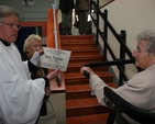 Pictured is the Revd Canon Desmond Sinnamon, Rector of Taney showing a plaque in honour of Tom Turner to his widow, Dolly. Dolly donated a chairlift to Taney parish in memory of her late husband. 