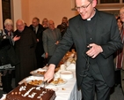 Canon Mark Gardner cuts the cake following his institution as the rector of the new parish of St Catherine and St James with St Audoen. 