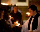 The rector of Zion Church, the Revd Stephen Farrell lighting candle at Zion carol service.