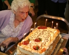 Olive Vaughan blowing out the candles on her birthday cake to celebrate her 100th Birthday in Brabazon house.