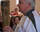 Part time Blessington parishioner, Derek Williams, makes his way up the aisle of St Mary’s Church with the torch he carried with the Olympic Flame in Cardiff. He was a special guest at the West Glendalough Children’s Choral Festival. 