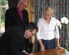 The Archbishop of Dublin, the Most Revd Dr John Neill and his wife Betty watch as the Ambassador of Palestine HE Dr Hikmat Ajjuri signs the visitors’ book during his visit to the See House in Dublin recently.