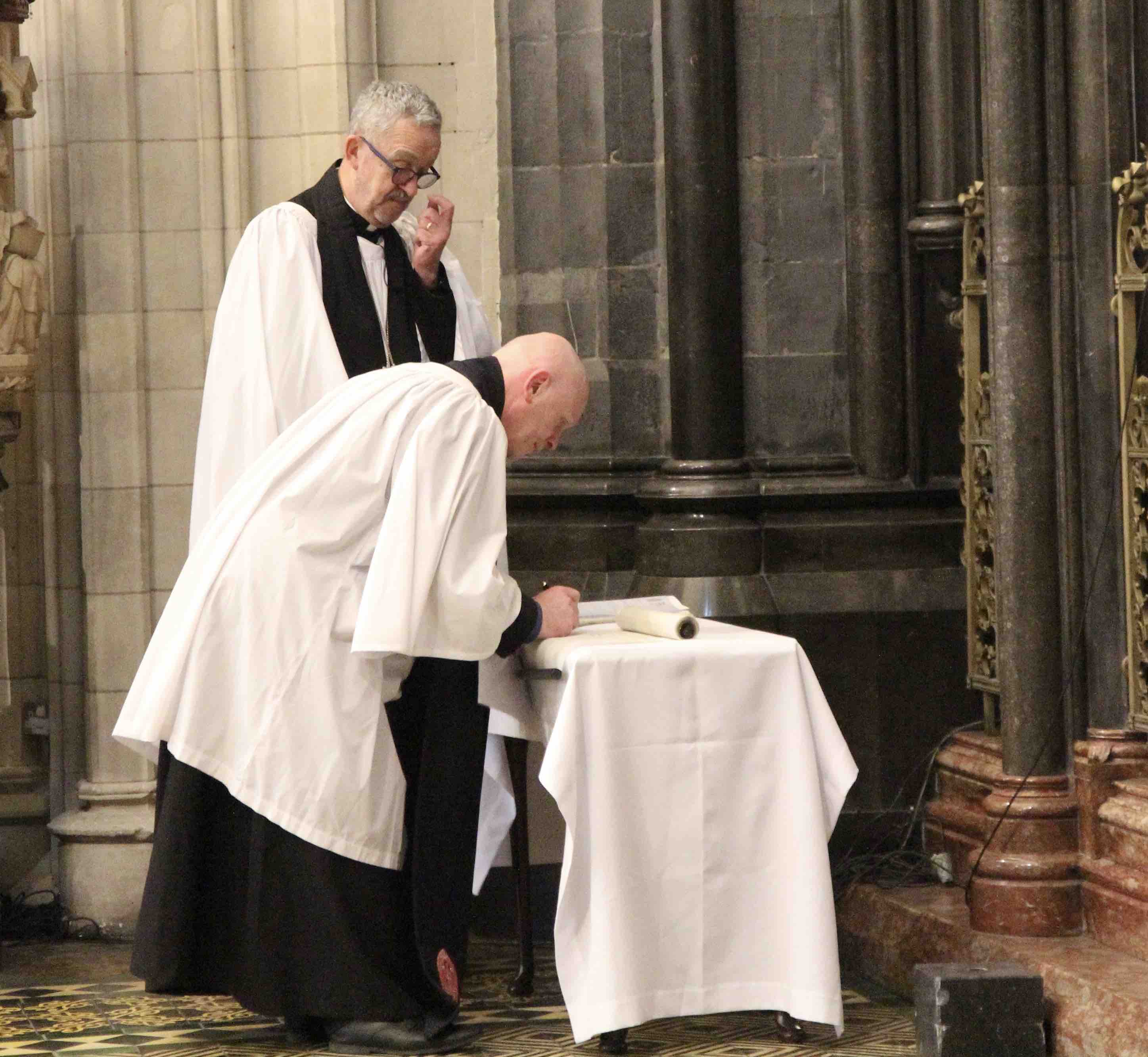 Canon Tom O'Brien signs the Cathedral Roll.