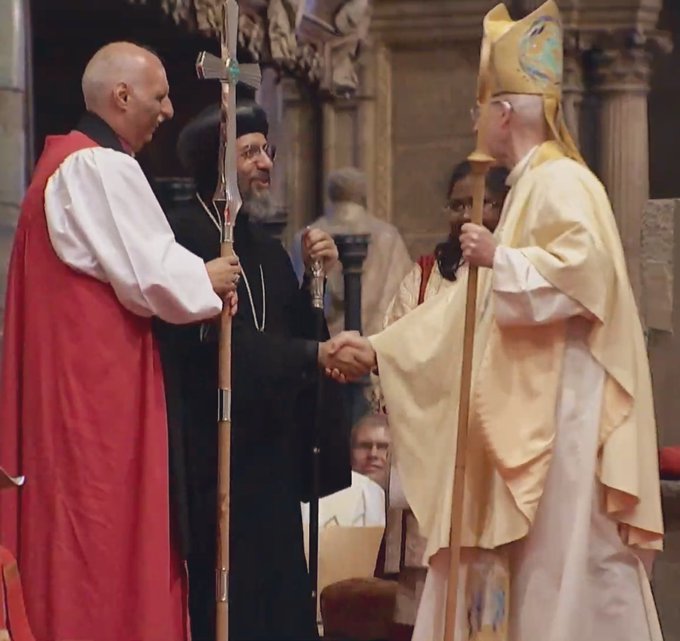 Archbishop Sami receiving the primatial cross.