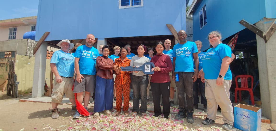 Handing over the key to their new home to Ms Salat and her family.