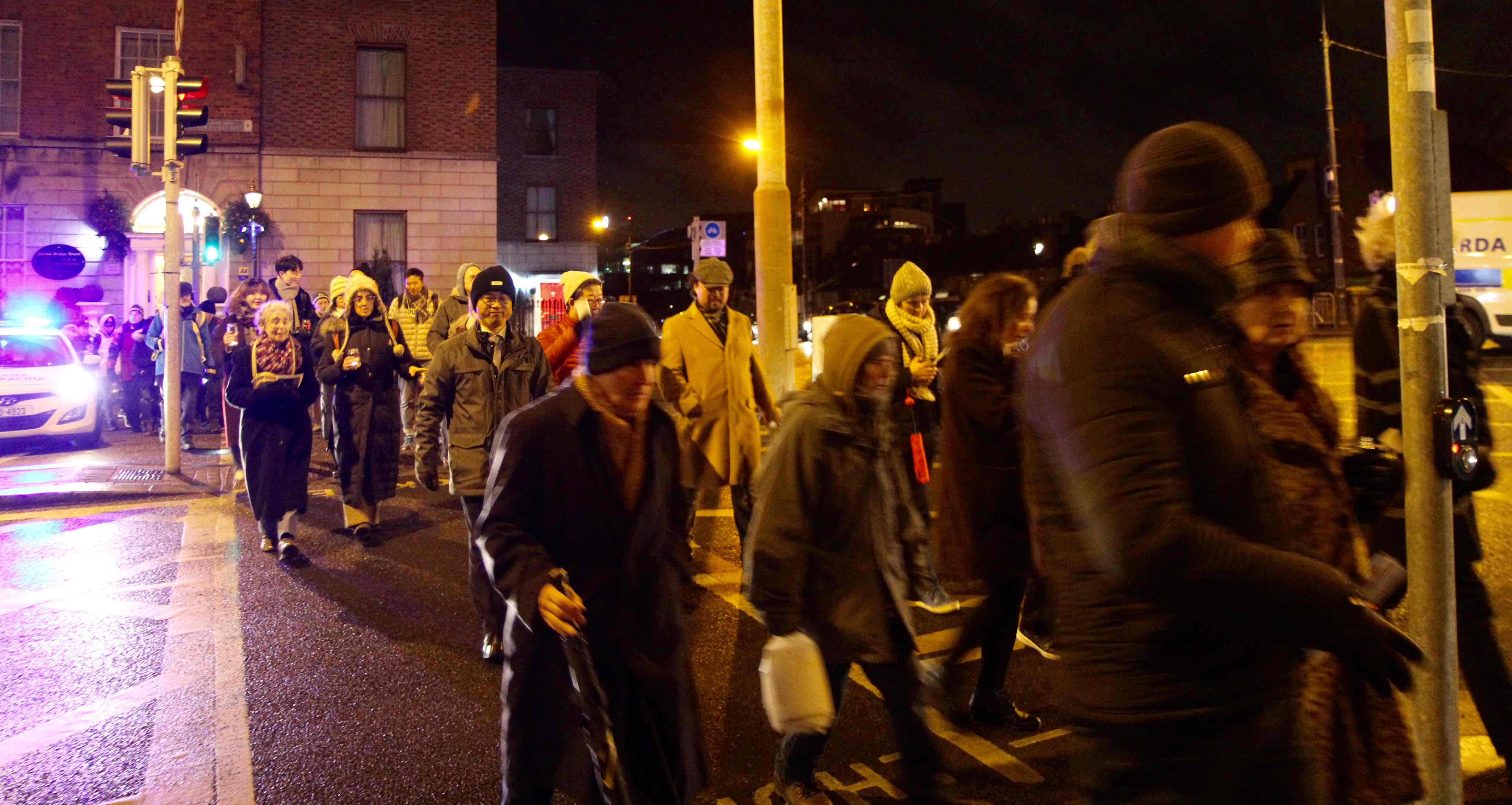 Participants in the Walk of Light cross Leeson Street with assistance from the Gardaí.