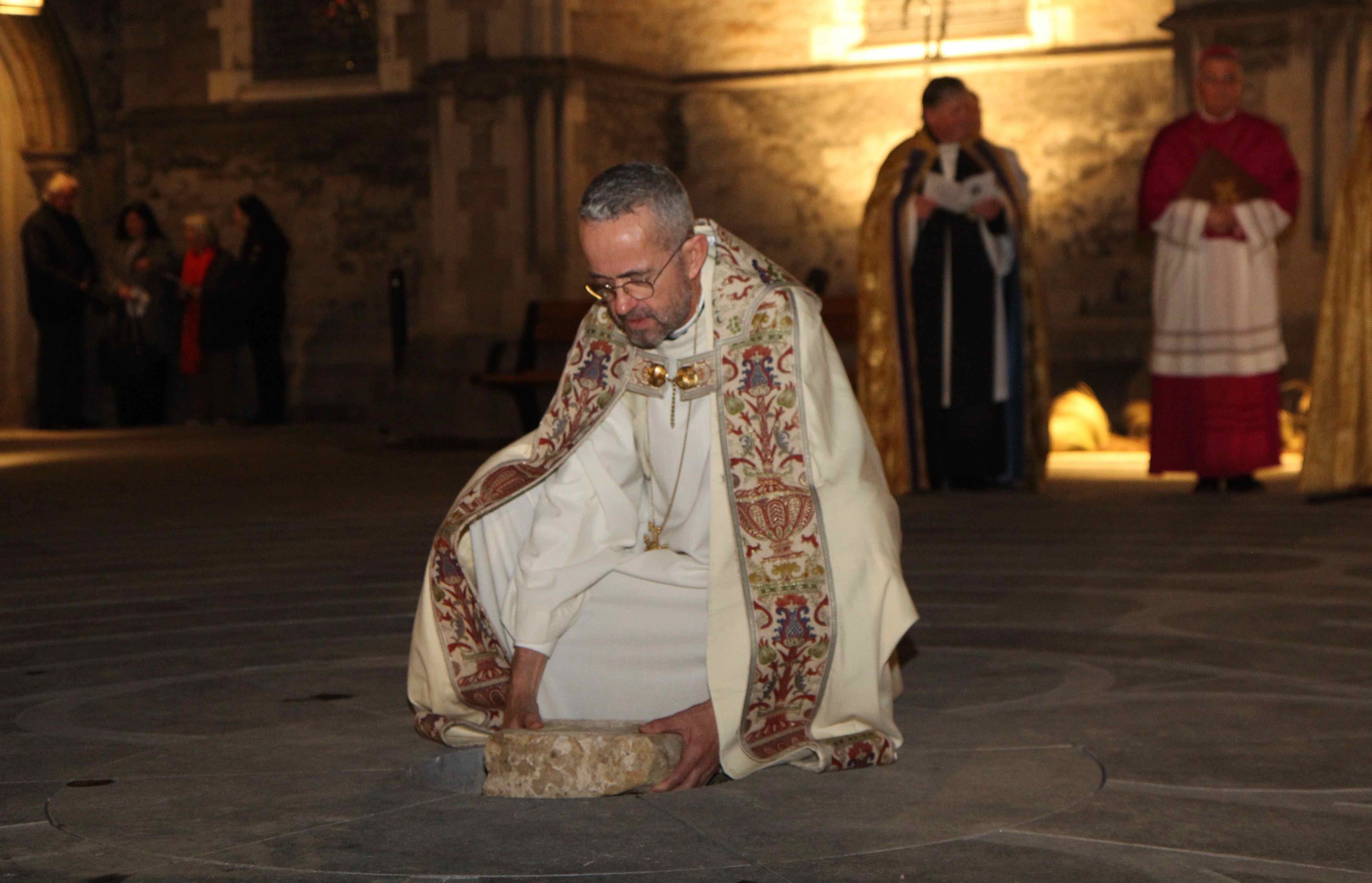 Dean Dermot Dunne places the centre stone in the new labyrinth at Christ Church Cathedral.