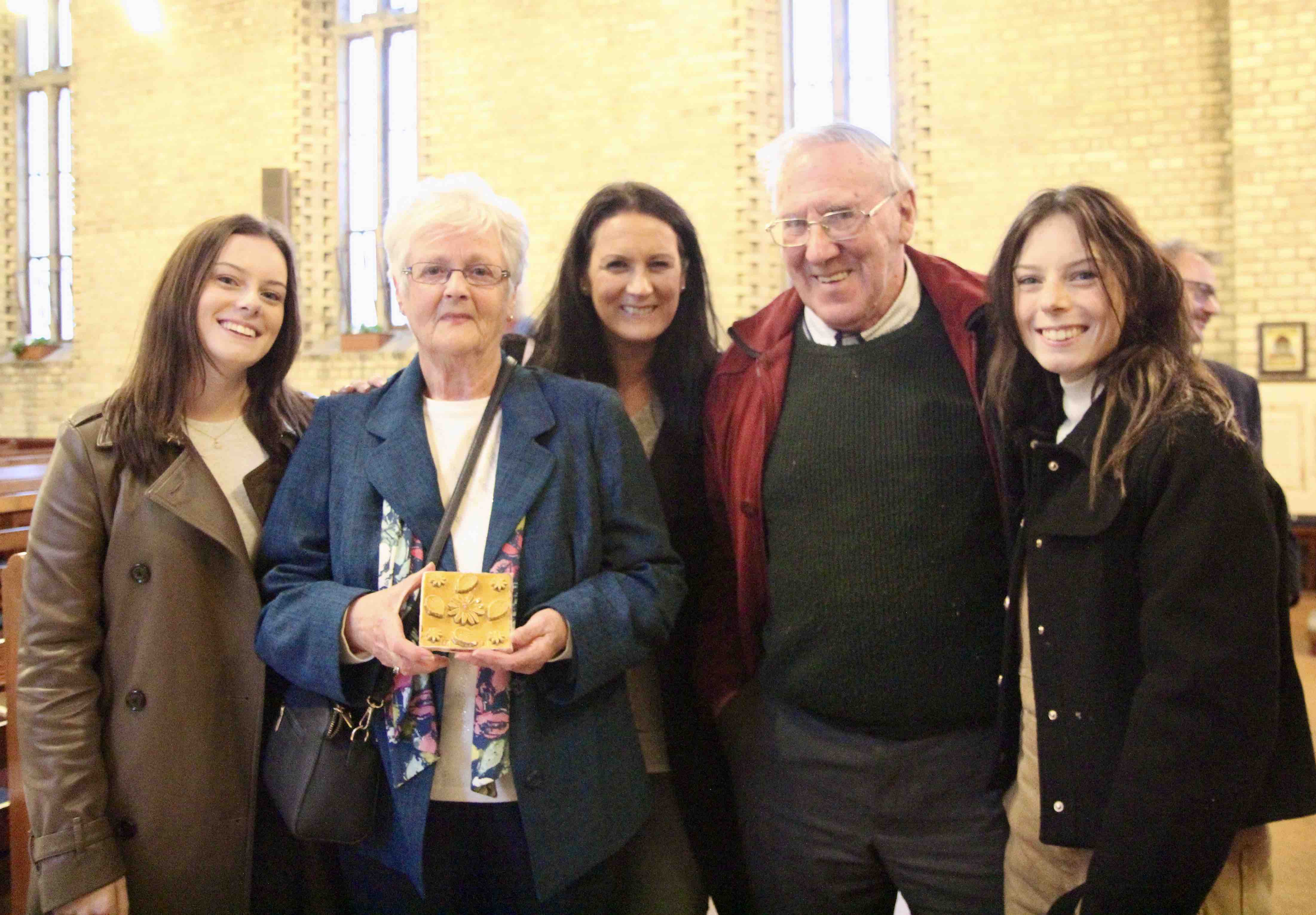 Jean Bovenizer and her family with one of the tiles she made.