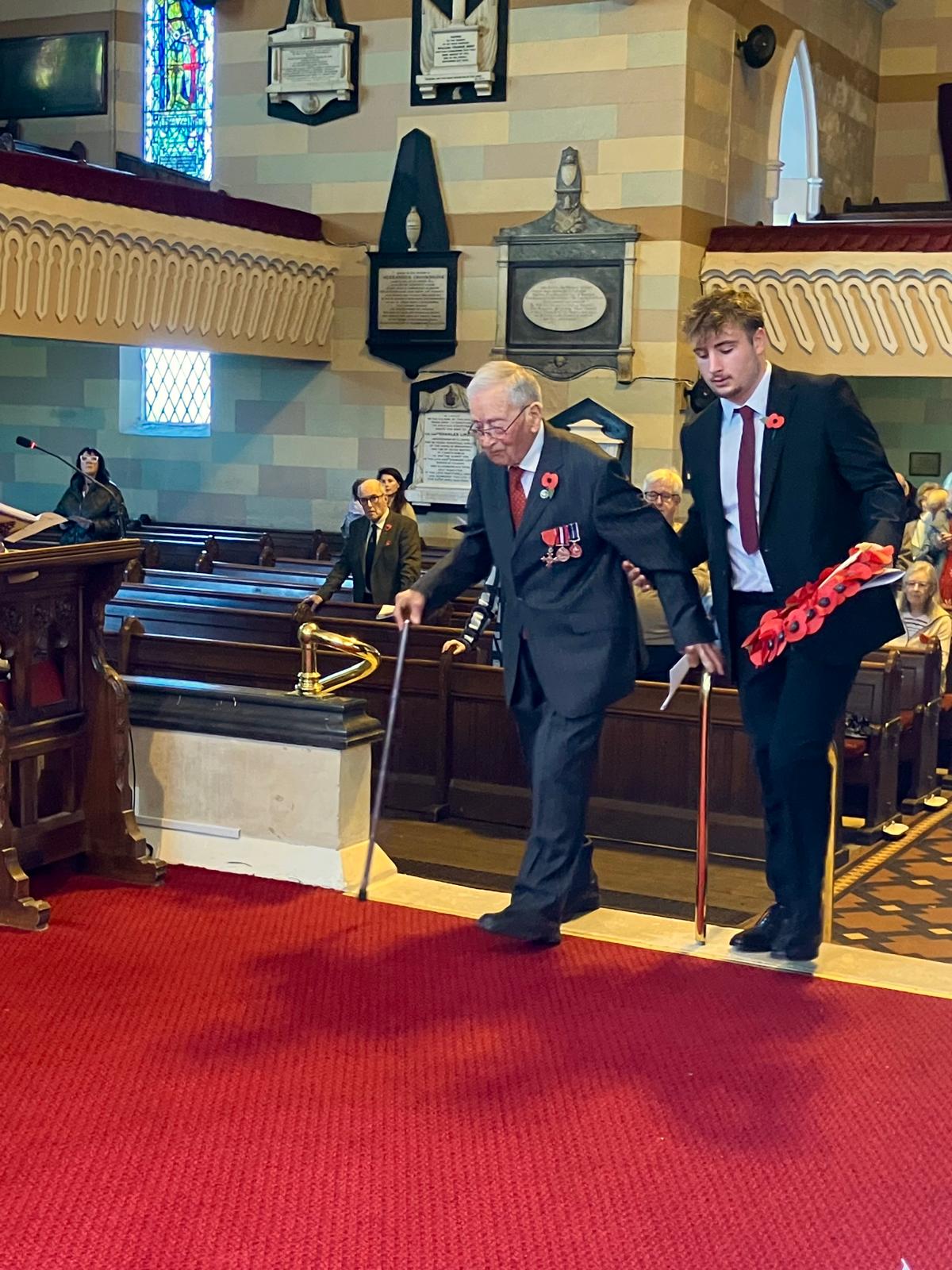 John Hewitson MBE lays a wreath assisted by Lewis Thornton.